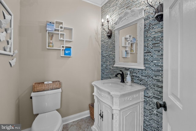 bathroom with toilet, vanity, tile patterned flooring, and crown molding