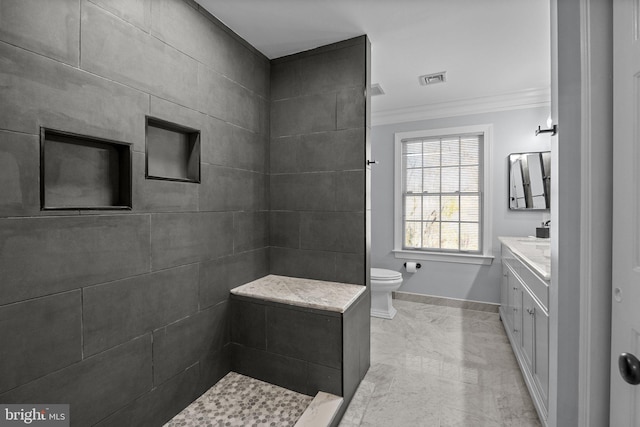 bathroom with toilet, vanity, a tile shower, and crown molding