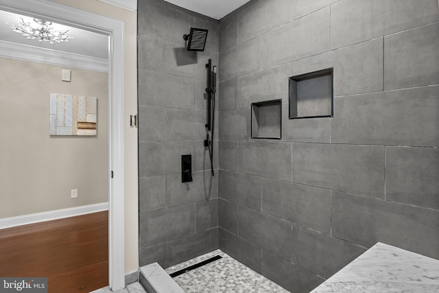 bathroom with tiled shower, hardwood / wood-style floors, and ornamental molding