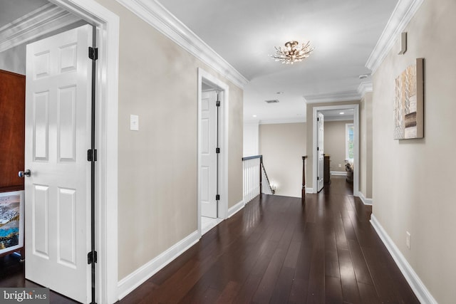 hall with dark wood-type flooring and ornamental molding