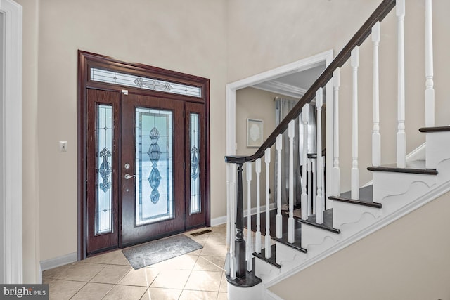 entrance foyer featuring light tile patterned floors, ornamental molding, and plenty of natural light