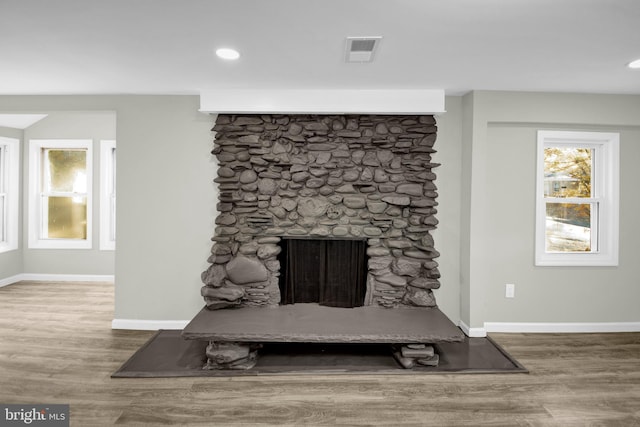 details featuring a stone fireplace and hardwood / wood-style flooring