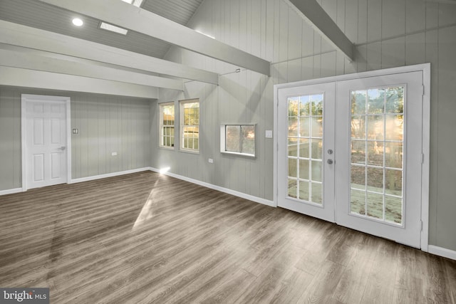 interior space with hardwood / wood-style flooring, french doors, and vaulted ceiling with beams