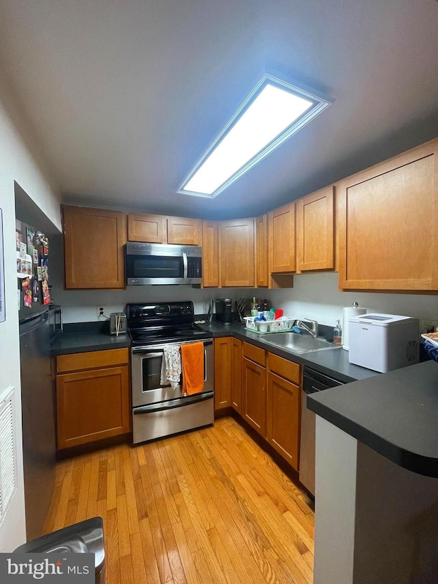 kitchen featuring light wood-type flooring, sink, and stainless steel appliances