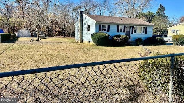 view of front of home featuring a front lawn and a storage unit