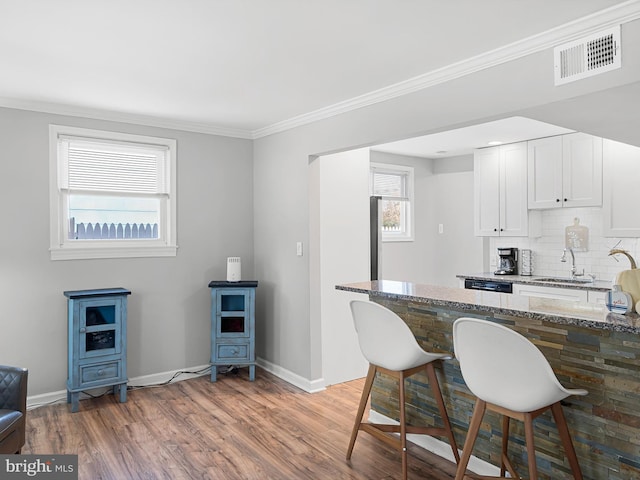 kitchen featuring white cabinetry, a wealth of natural light, dark stone counters, and dark hardwood / wood-style floors