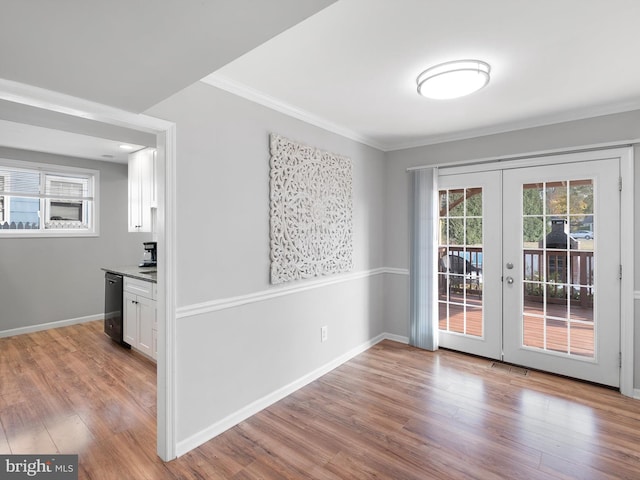 unfurnished dining area featuring wine cooler, light wood-type flooring, french doors, and ornamental molding