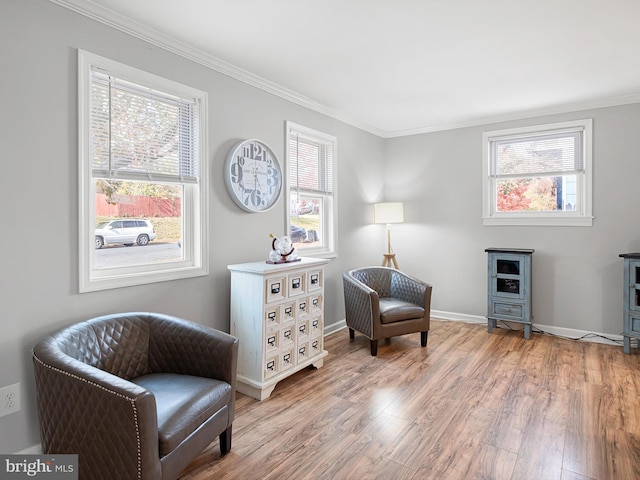 sitting room featuring plenty of natural light, wood-type flooring, and crown molding