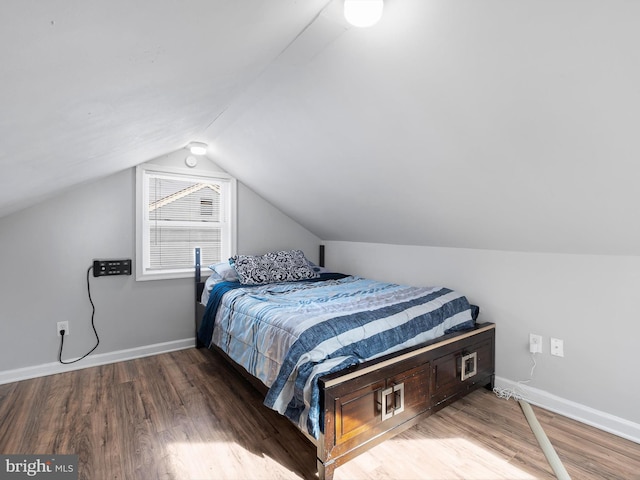 bedroom with wood-type flooring and vaulted ceiling