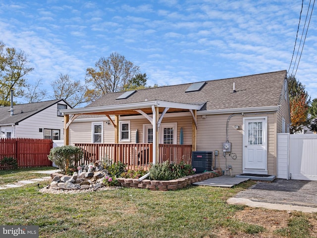 back of property with central AC and a yard