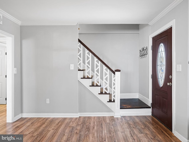 entryway with wood-type flooring and ornamental molding