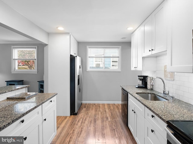 kitchen with white cabinets, dark stone countertops, sink, and stainless steel appliances