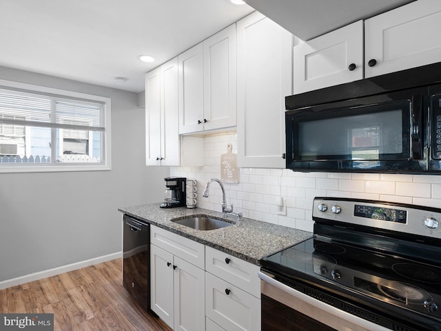 kitchen with wood-type flooring, white cabinetry, sink, and black appliances