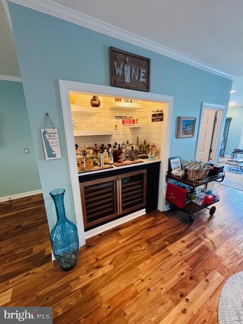 bar featuring hardwood / wood-style flooring and crown molding