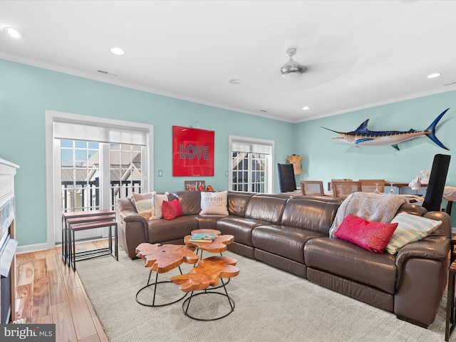 living room with ceiling fan, light wood-type flooring, and ornamental molding