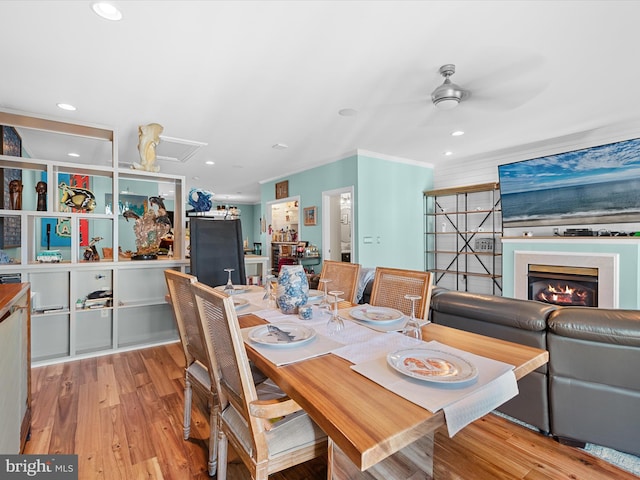 dining room featuring light wood-type flooring, ceiling fan, and crown molding