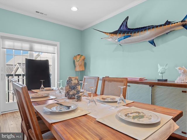 dining space with hardwood / wood-style flooring and ornamental molding