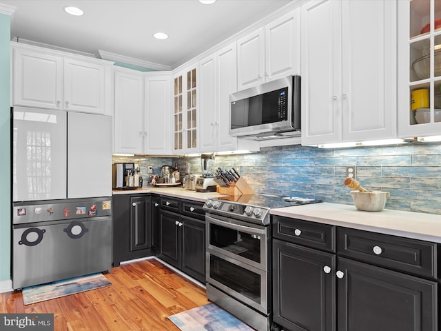 kitchen featuring tasteful backsplash, ornamental molding, stainless steel appliances, light hardwood / wood-style floors, and white cabinetry