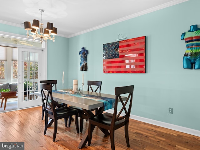 dining room featuring crown molding, an inviting chandelier, and hardwood / wood-style flooring