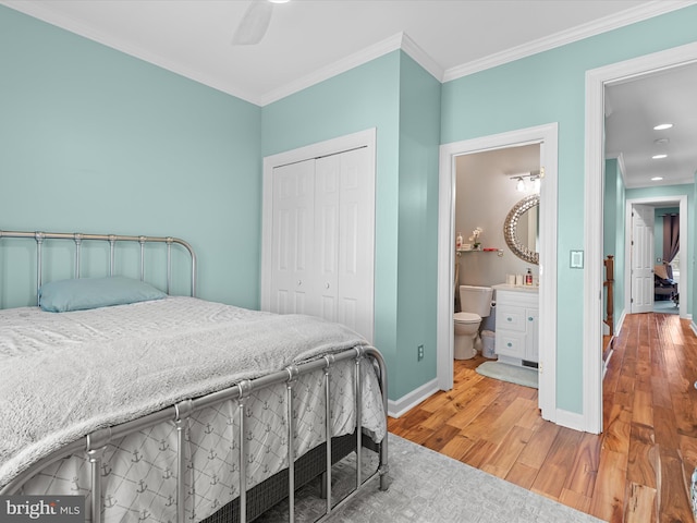 bedroom featuring ornamental molding, ceiling fan, hardwood / wood-style floors, connected bathroom, and a closet