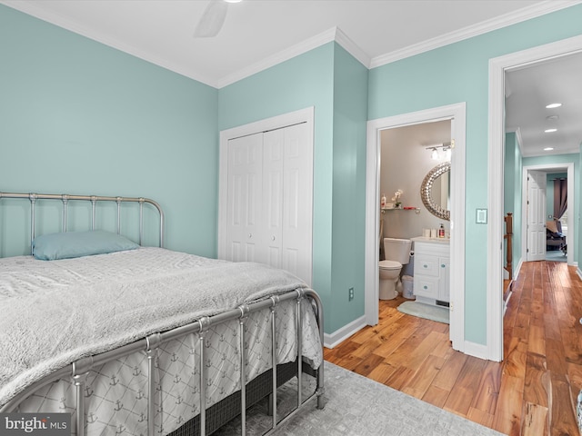 37601 Atlantic St Unit 8, Rehoboth Beach, DE 19971 - bedroom with ornamental molding, wood finished floors, a closet, baseboards, and connected bathroom