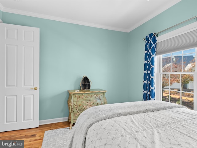 bedroom with hardwood / wood-style flooring and crown molding