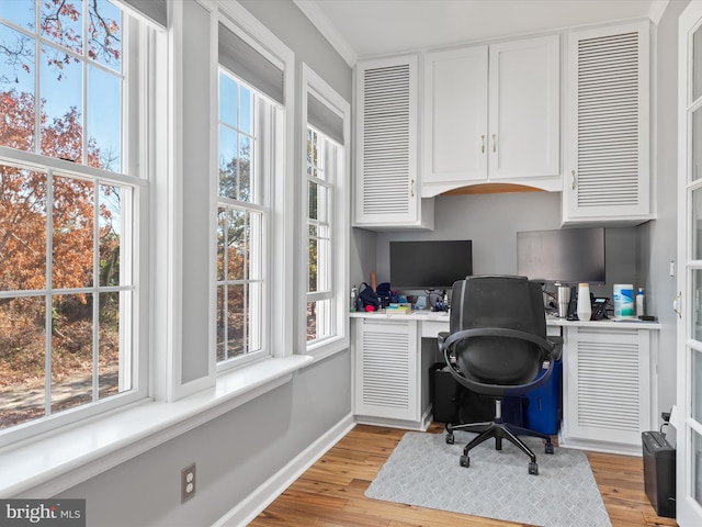 office space featuring light wood-type flooring and built in desk