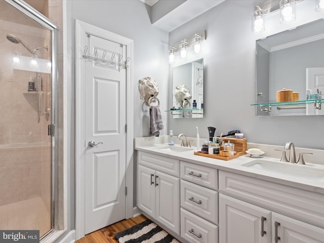 bathroom with hardwood / wood-style flooring, vanity, crown molding, and walk in shower