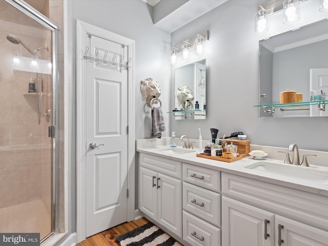 37601 Atlantic St Unit 8, Rehoboth Beach, DE 19971 - bathroom featuring a shower stall, ornamental molding, double vanity, and wood finished floors