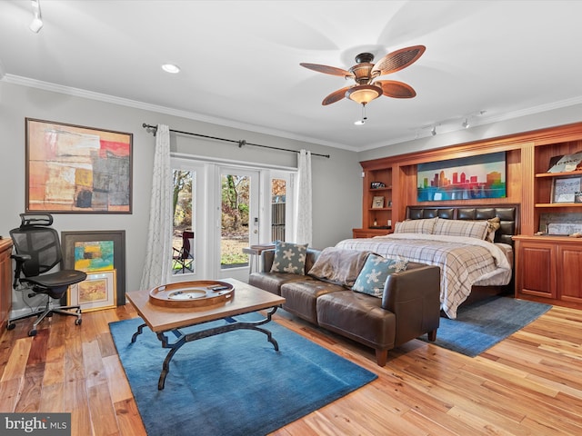 bedroom featuring rail lighting, ceiling fan, crown molding, and light hardwood / wood-style flooring