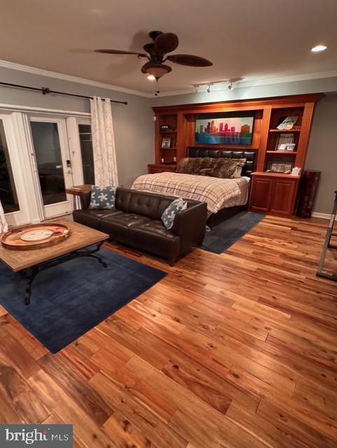 bedroom with ceiling fan, crown molding, and light hardwood / wood-style flooring