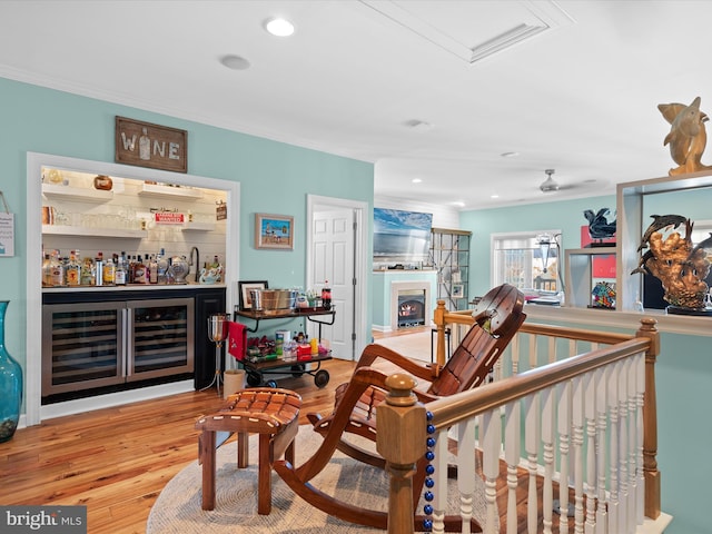 37601 Atlantic St Unit 8, Rehoboth Beach, DE 19971 - living area featuring beverage cooler, a bar, ornamental molding, a warm lit fireplace, and wood finished floors