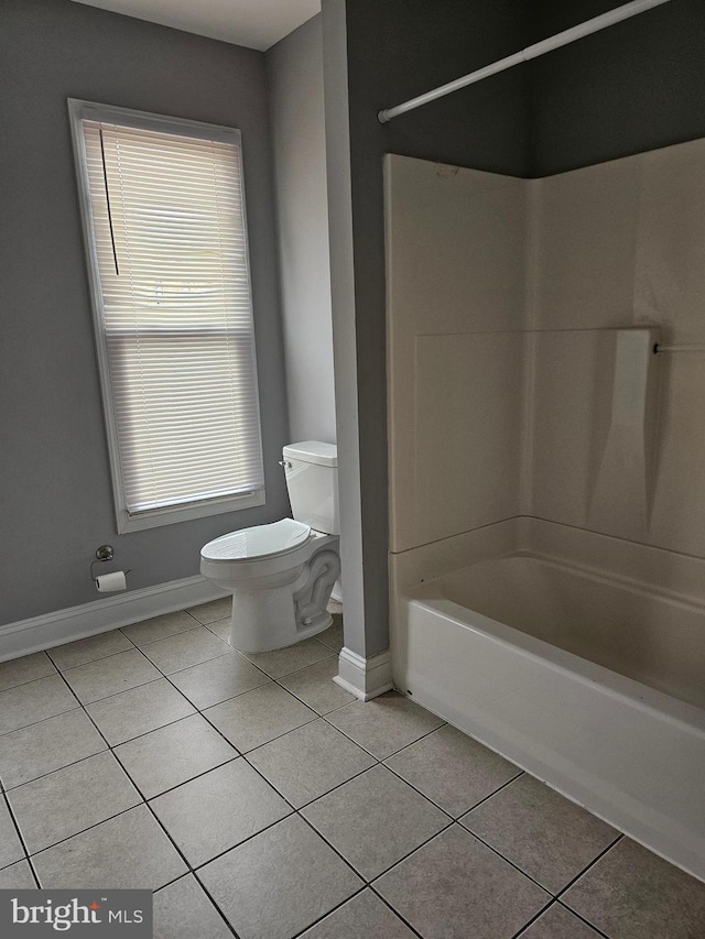 bathroom featuring tile patterned floors, bathing tub / shower combination, and toilet