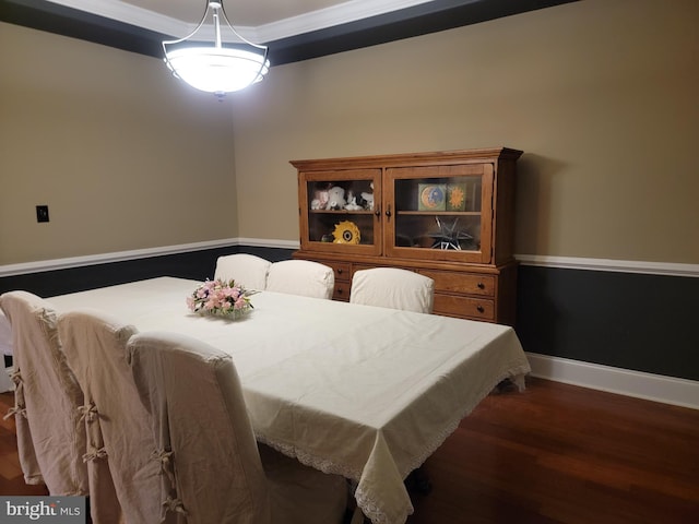 dining room with dark hardwood / wood-style floors and crown molding