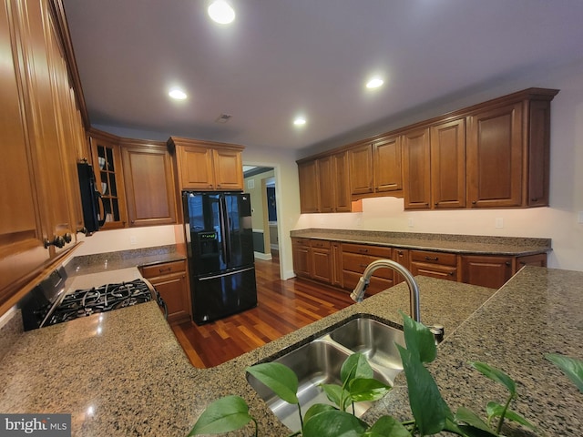 kitchen featuring sink, dark wood-type flooring, and black appliances