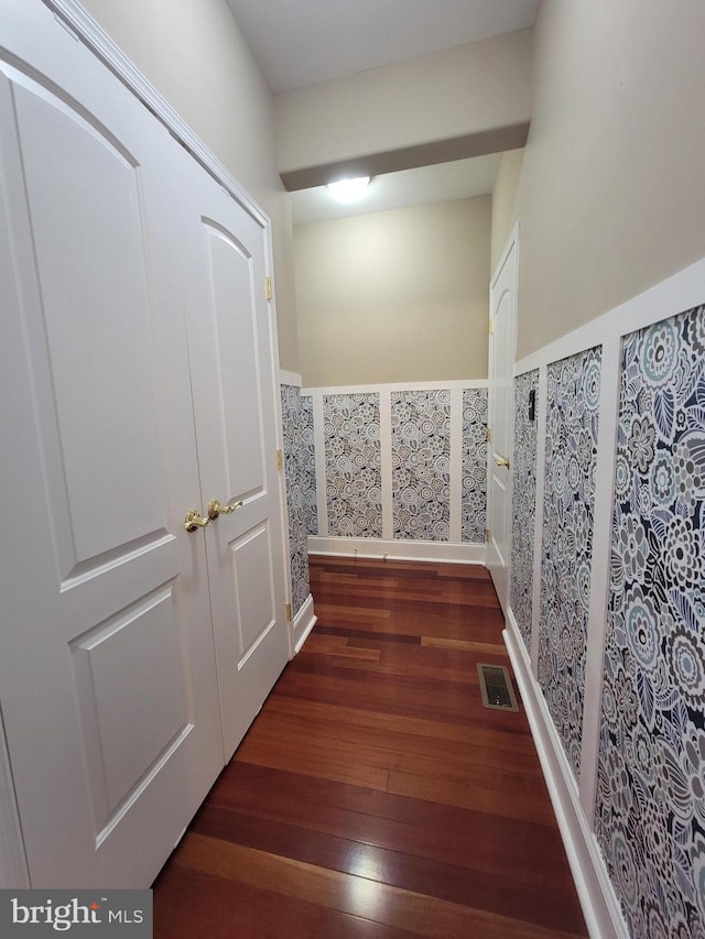 corridor with dark hardwood / wood-style flooring and tile walls