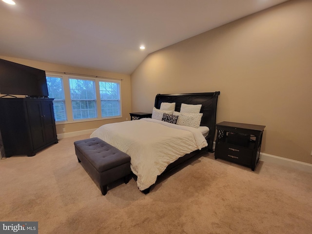 bedroom with light colored carpet and lofted ceiling