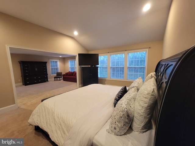 bedroom featuring light carpet and vaulted ceiling