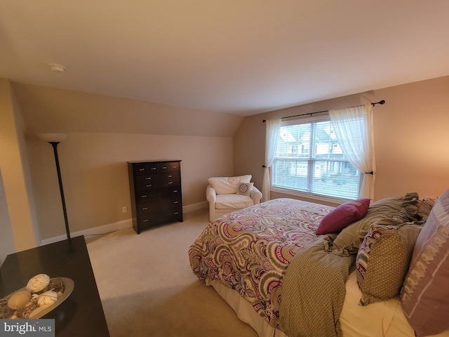 bedroom featuring light carpet and vaulted ceiling