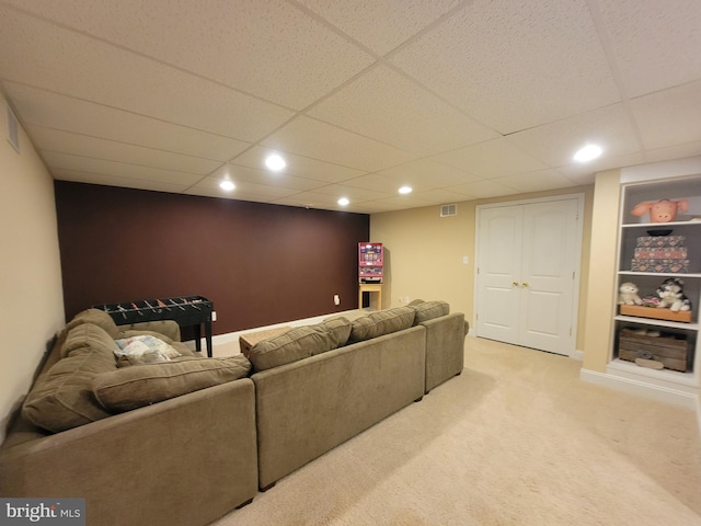 living room with a drop ceiling and carpet floors