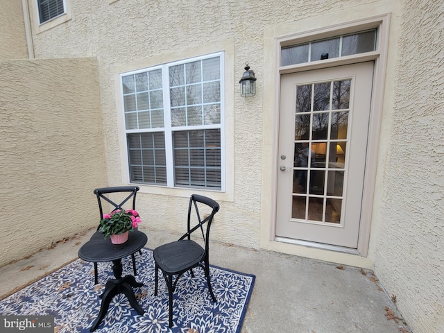 view of exterior entry featuring a patio