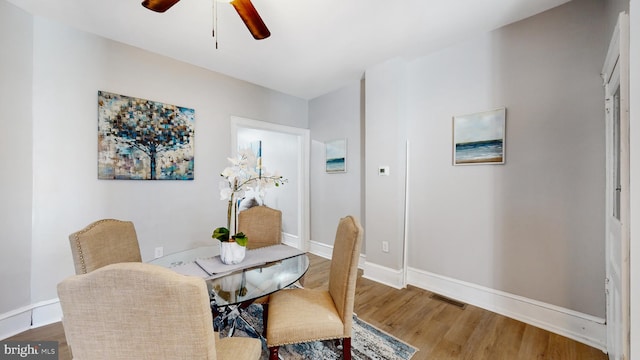 dining space featuring wood-type flooring and ceiling fan