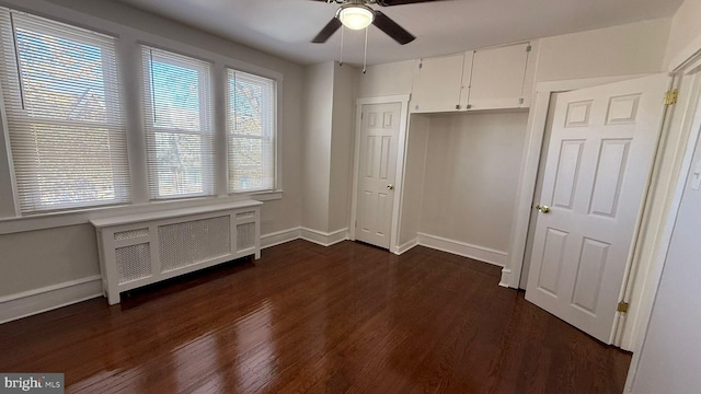 unfurnished bedroom featuring radiator, ceiling fan, and dark hardwood / wood-style flooring