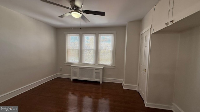 spare room featuring dark hardwood / wood-style flooring and ceiling fan