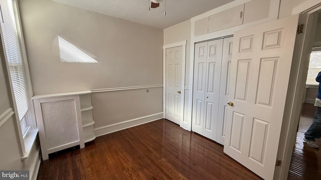 unfurnished bedroom featuring dark hardwood / wood-style flooring, a closet, and ceiling fan