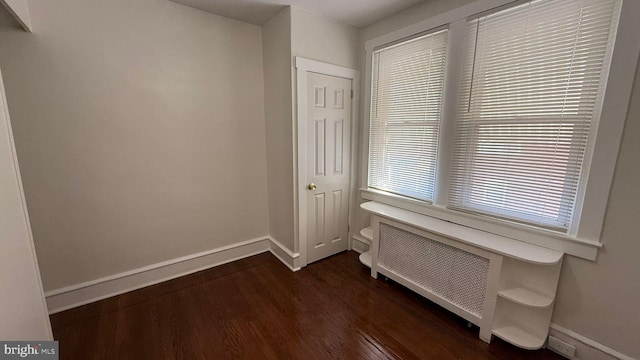 corridor featuring dark hardwood / wood-style floors and radiator