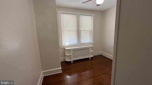 unfurnished room with a wealth of natural light, dark wood-type flooring, and ceiling fan