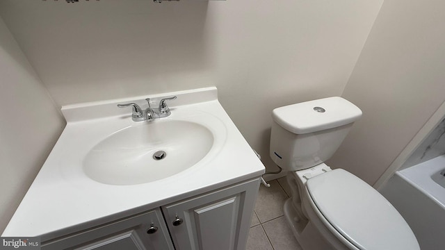 bathroom with toilet, vanity, and tile patterned flooring