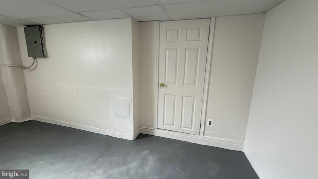 basement featuring electric panel and a paneled ceiling