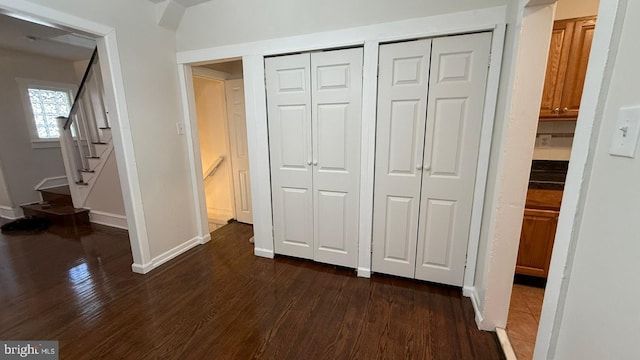 unfurnished bedroom with multiple closets and dark hardwood / wood-style floors